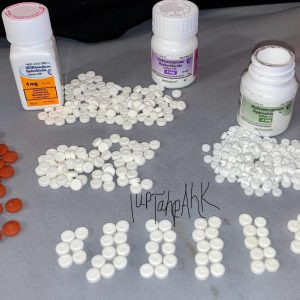 Authentic Dilaudid hydromorphone tablets in generic pharmacy packaging on a clean white countertop.